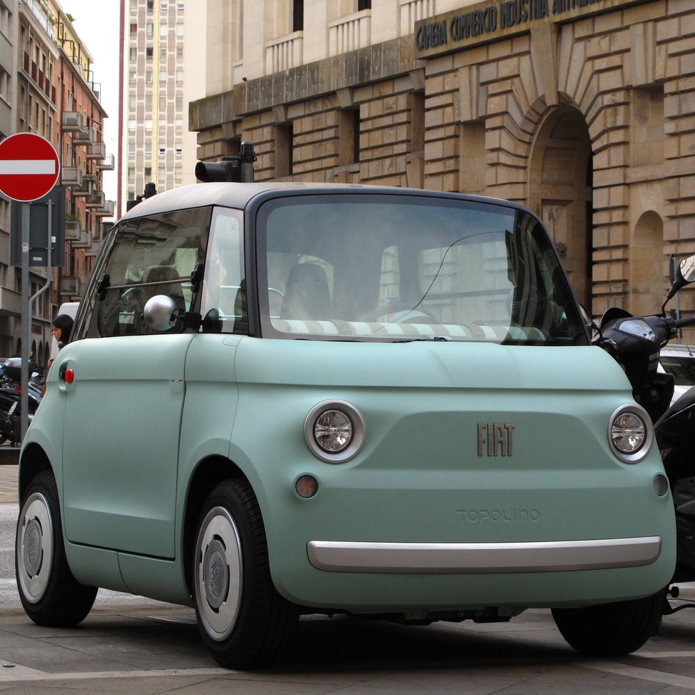 Une Fiat Topolino vert d’eau garée dans la rue